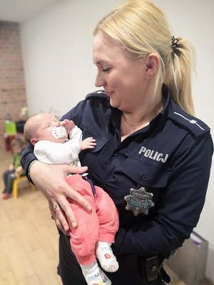 Policjantka mł. asp. Romana Kaczmarek-Stasiak trzyma na rękach małego Jacusia